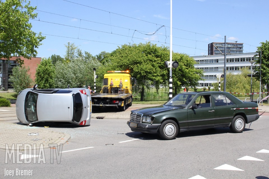 Auto op zijn kant na aanrijding Piersonstraat Schiedam
