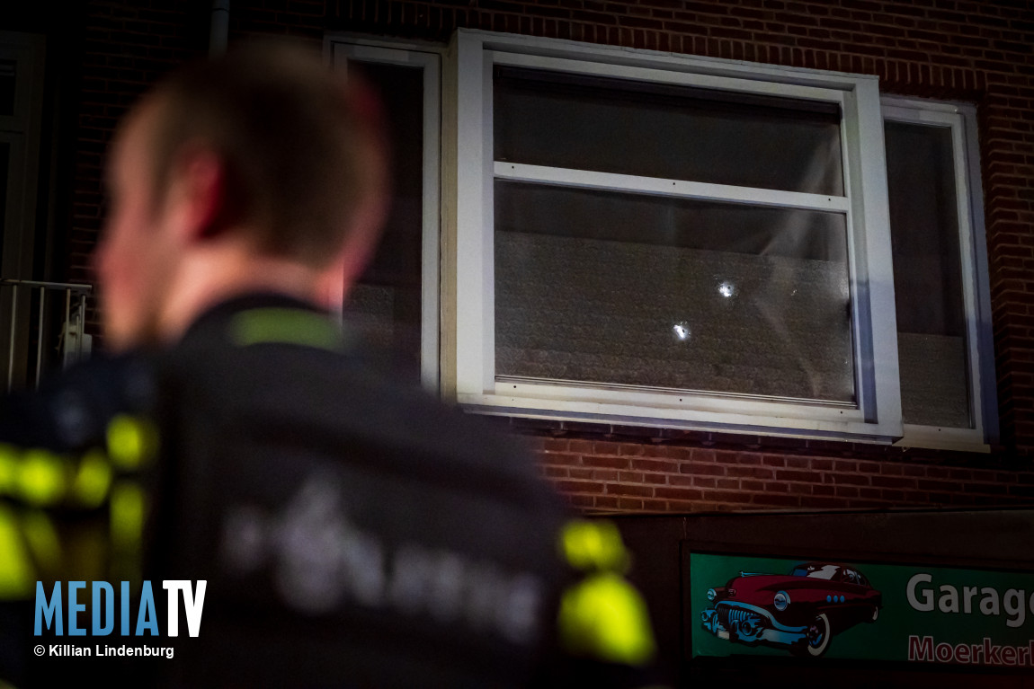 Kogelgaten in raam na beschieting van woning Moerkerkestraat Rotterdam