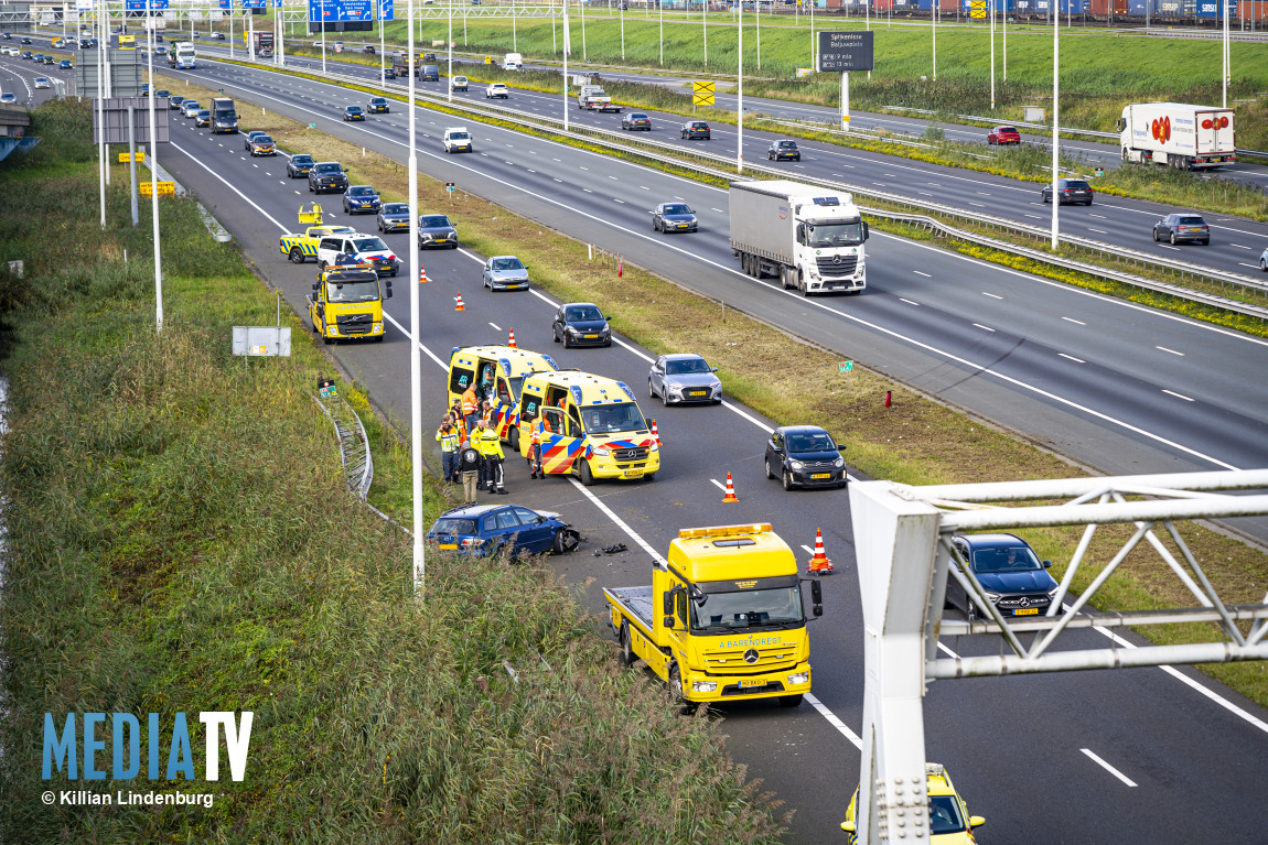 Auto rijdt van hoofdrijbaan tegen vangrail parallelbaan A15 Rotterdam-Heijplaat