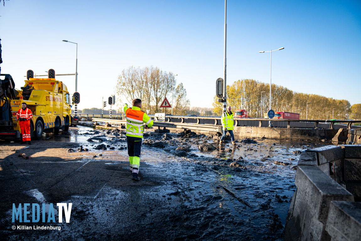 Vrachtwagen met modder gekanteld op viaduct, auto's op snelweg besmeurd A15 Botlek Rotterdam